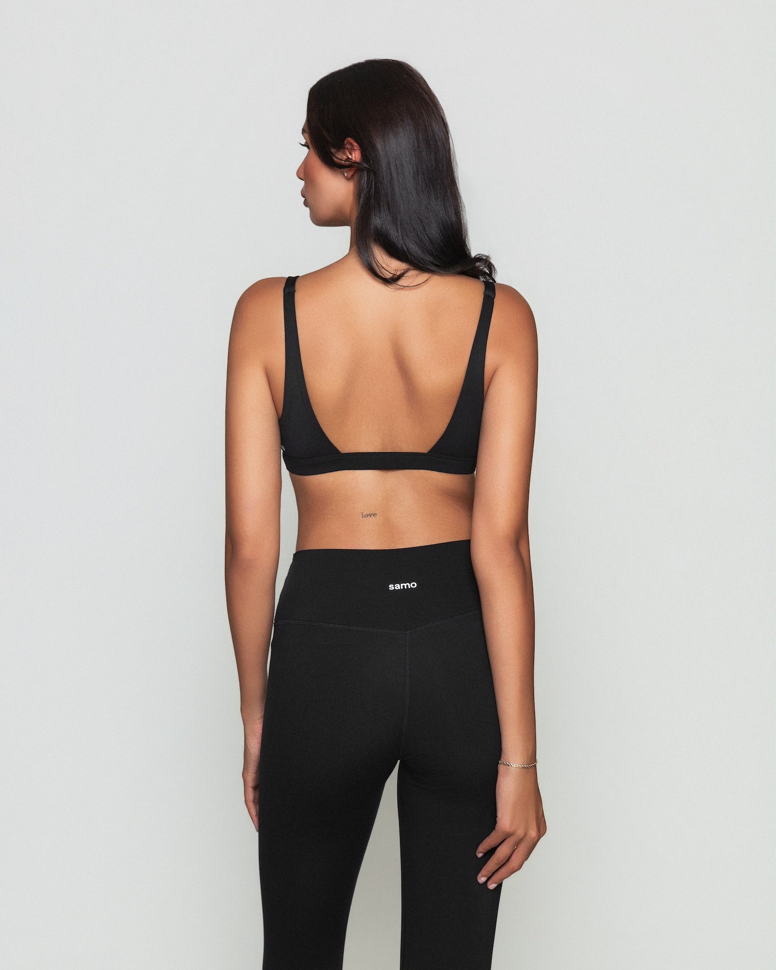Frau trägt schwarzen Contour Bra und schwarze Seamless Pilates Leggings von shop-samo.com