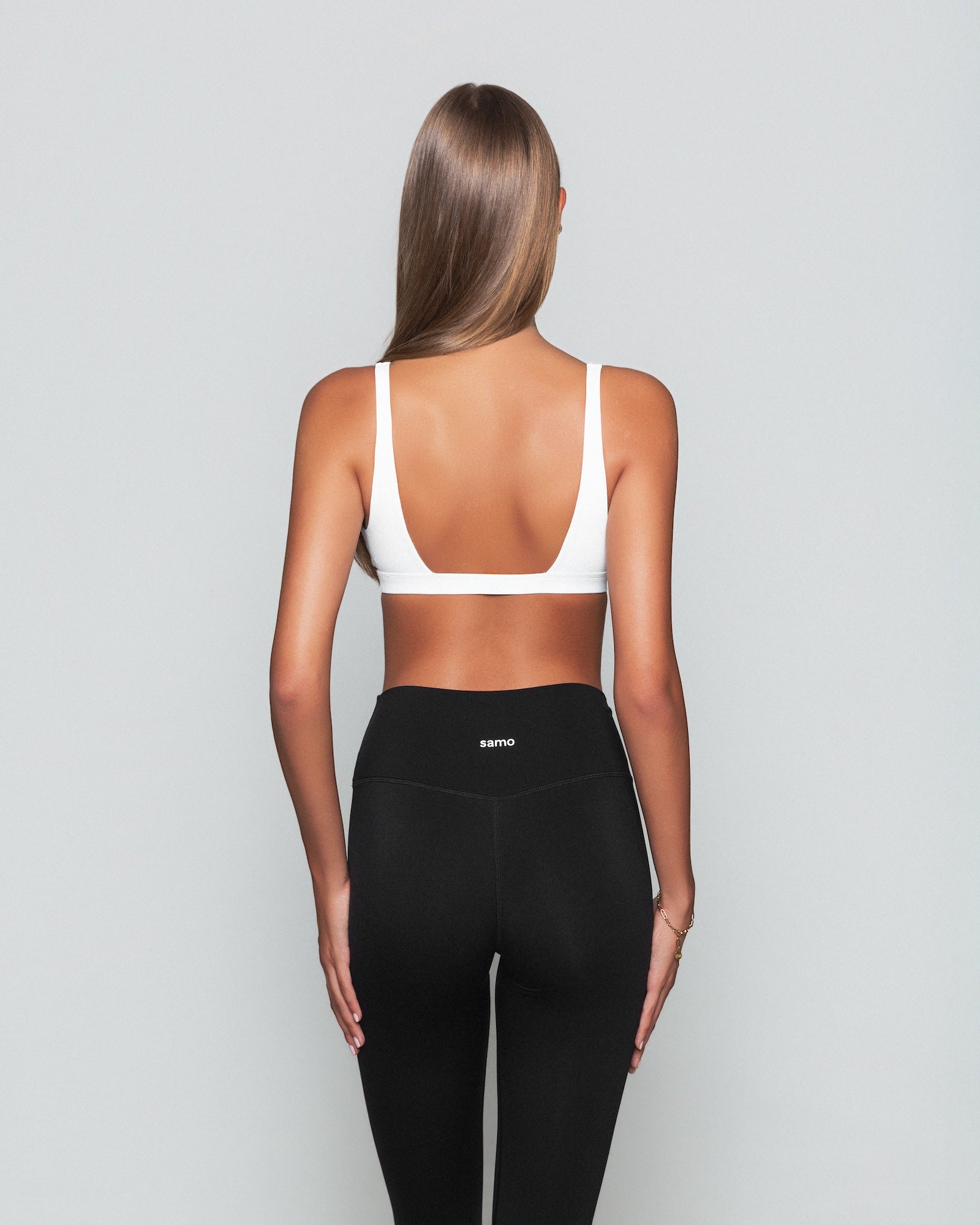 Frau trägt weißen Contour Bra und schwarze Seamless Pilates Leggings von shop-samo.com