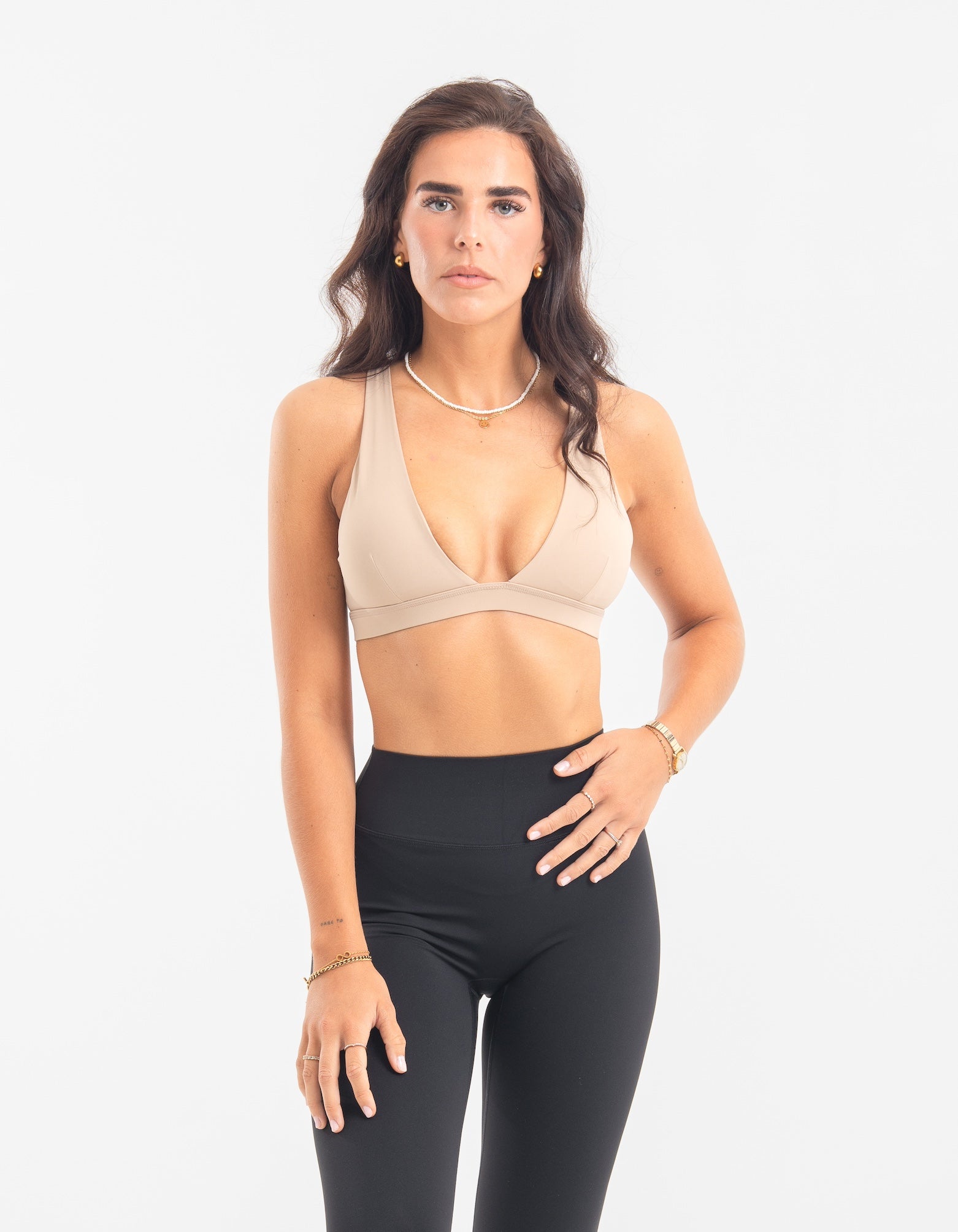 Frau trägt Contour Bra in Sand Beige und schwarze High-Waist Leggings von shop-samo.com