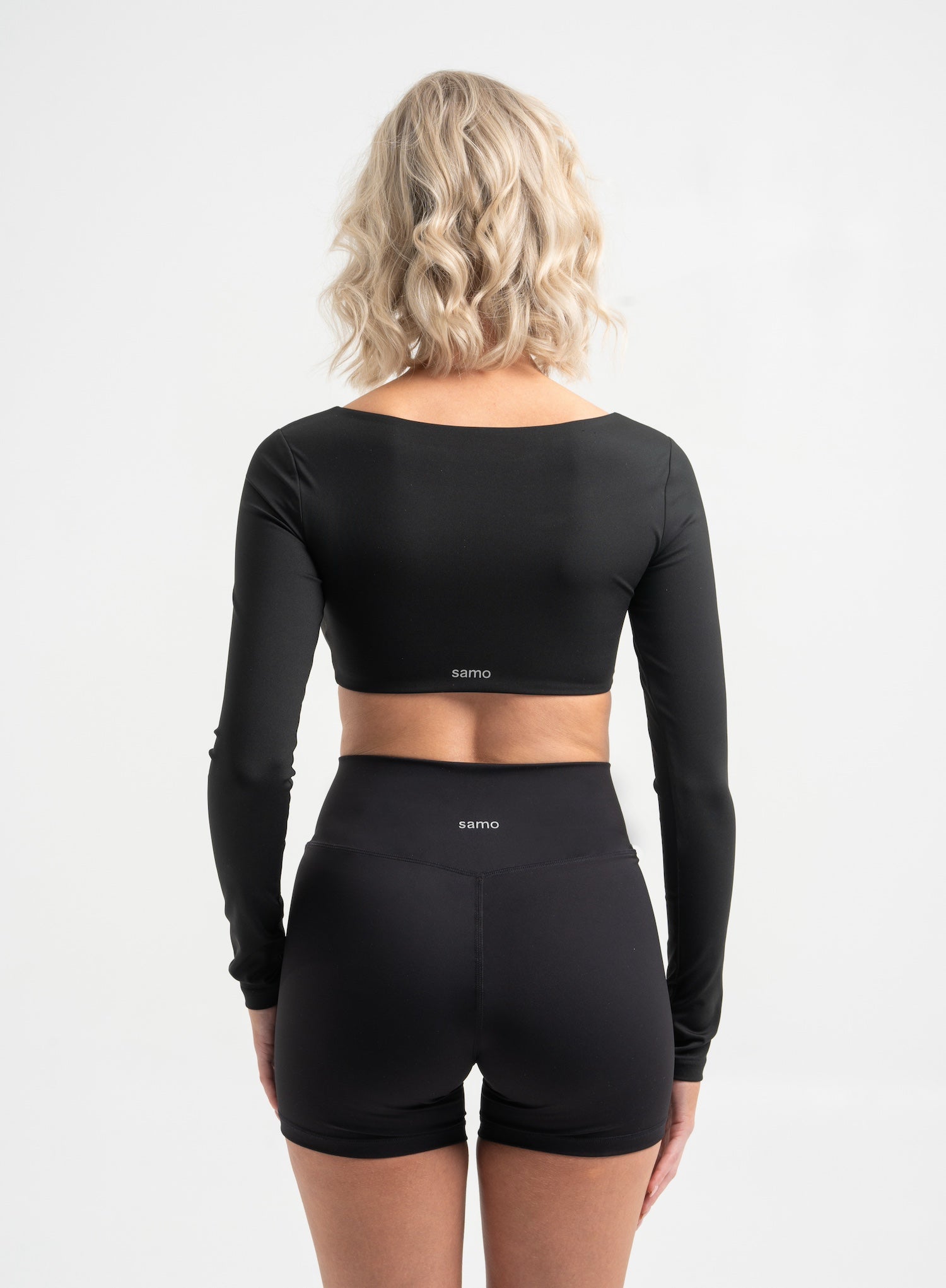 Frau trägt schwarze Cross Over Shorts und Cropped Longsleeve von shop-samo.com