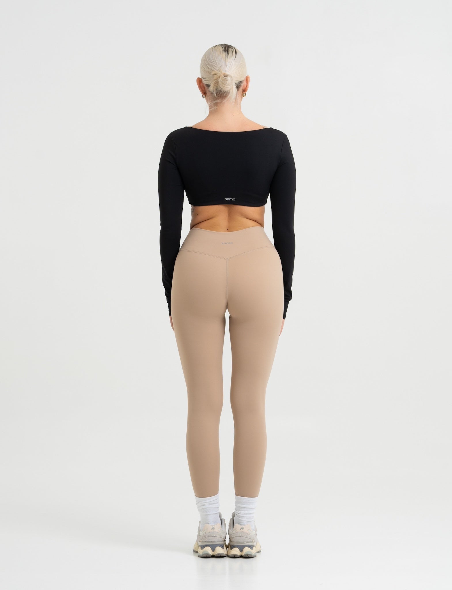 Frau trägt Seamless Pilates Leggings in Sand mit schwarzem Cropped Longsleeve von shop-samo.com