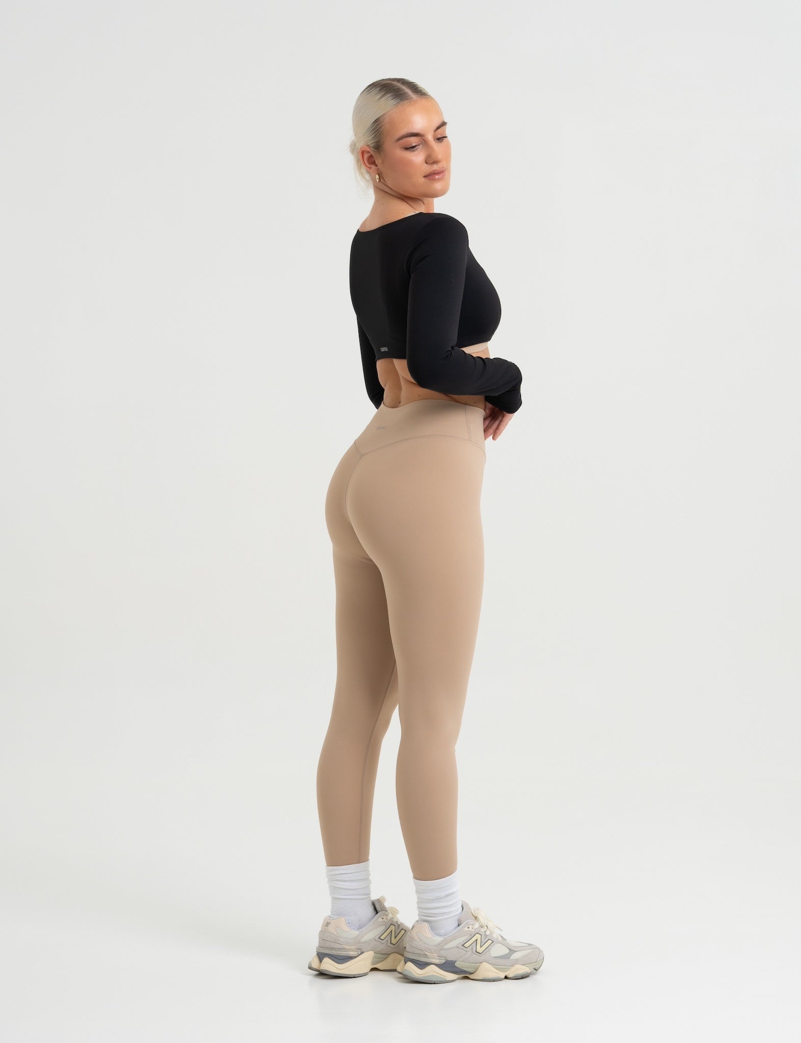 Frau trägt Seamless Pilates Leggings in Sand mit schwarzem Cropped Longsleeve von shop-samo.com