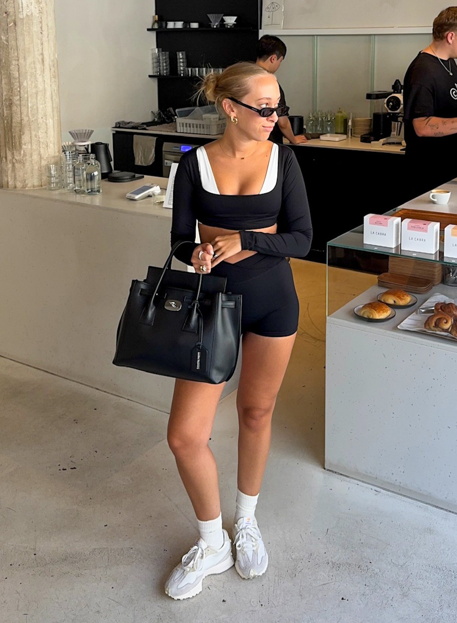 Frau trägt schwarze Cross Over Shorts und Cropped Longsleeve von shop-samo.com