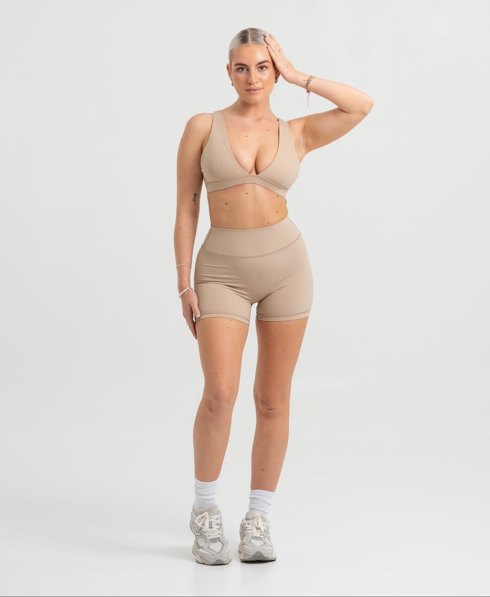 Frau trägt Seamless Pilates Shorts und Sport-BH in Sand Beige von shop-samo.com