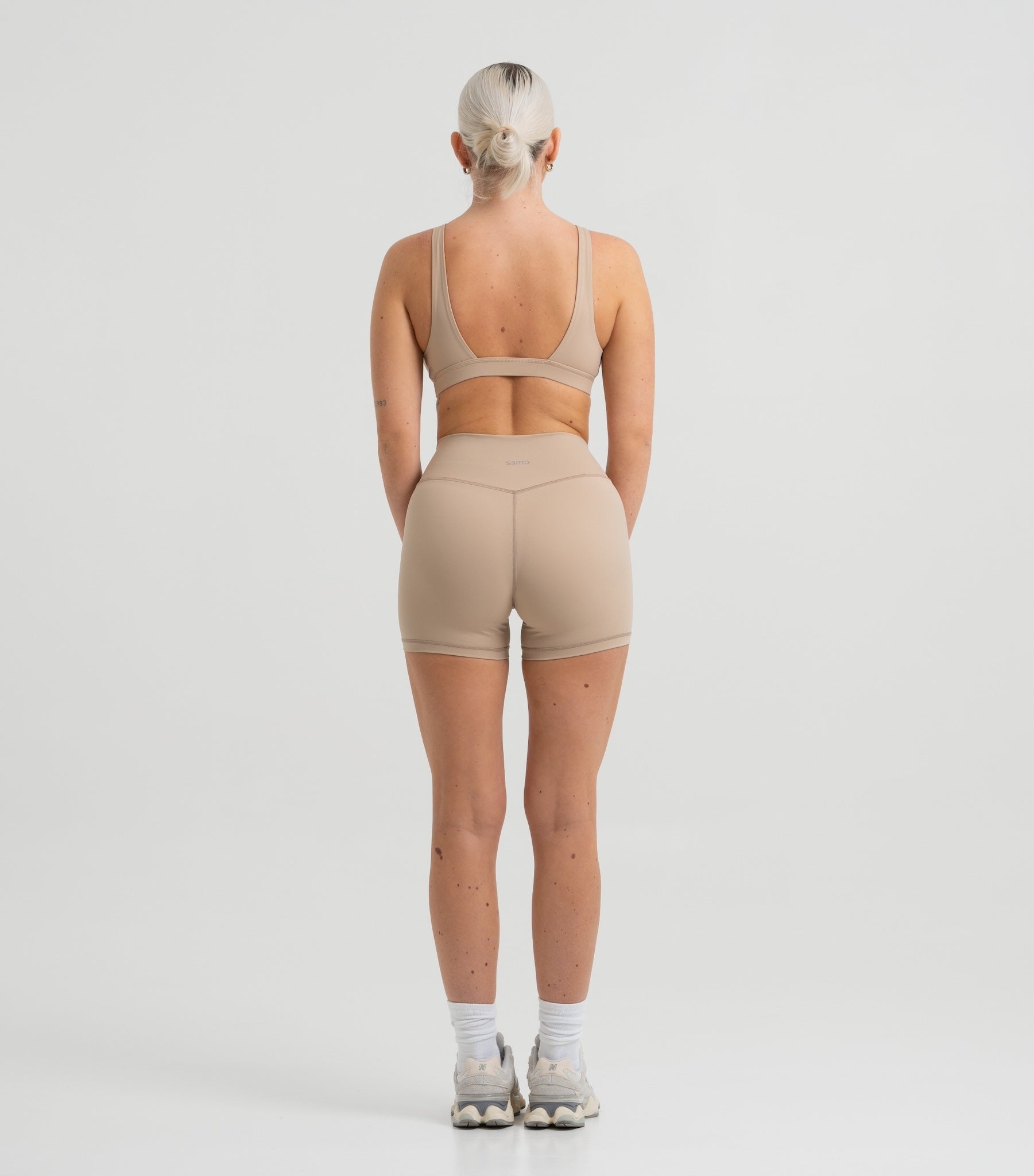 Frau trägt Seamless Pilates Shorts und Sport-BH in Sand Beige von shop-samo.com