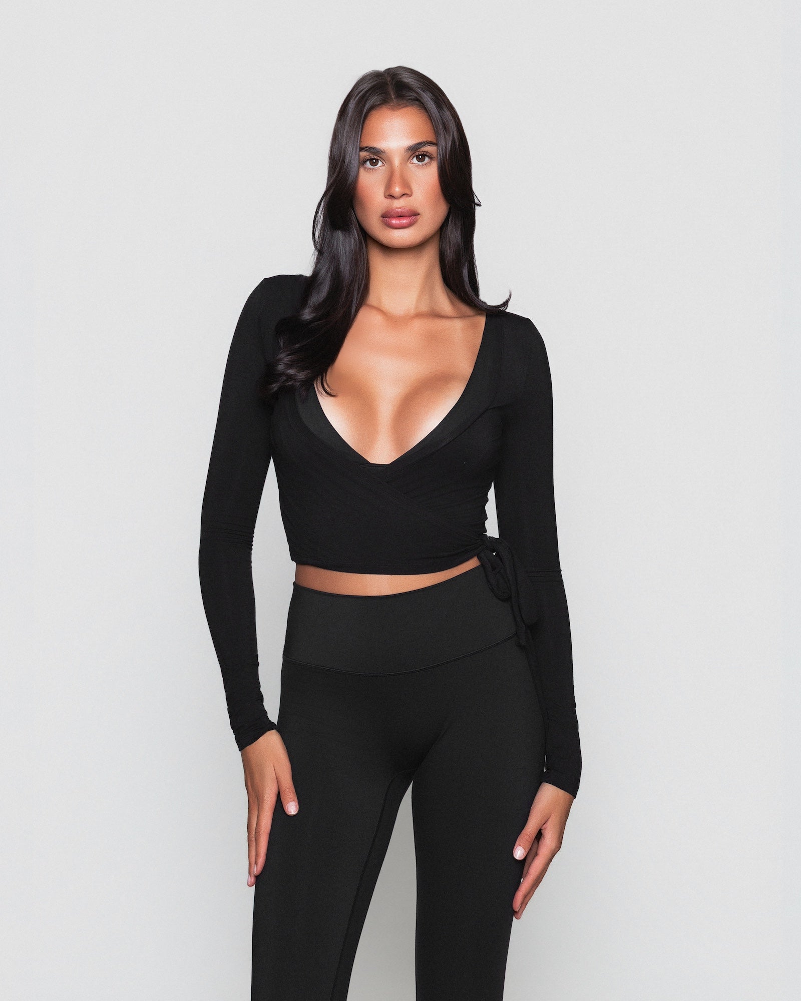 Frau trägt schwarzes Pilates Wickeloberteil von shop-samo.com