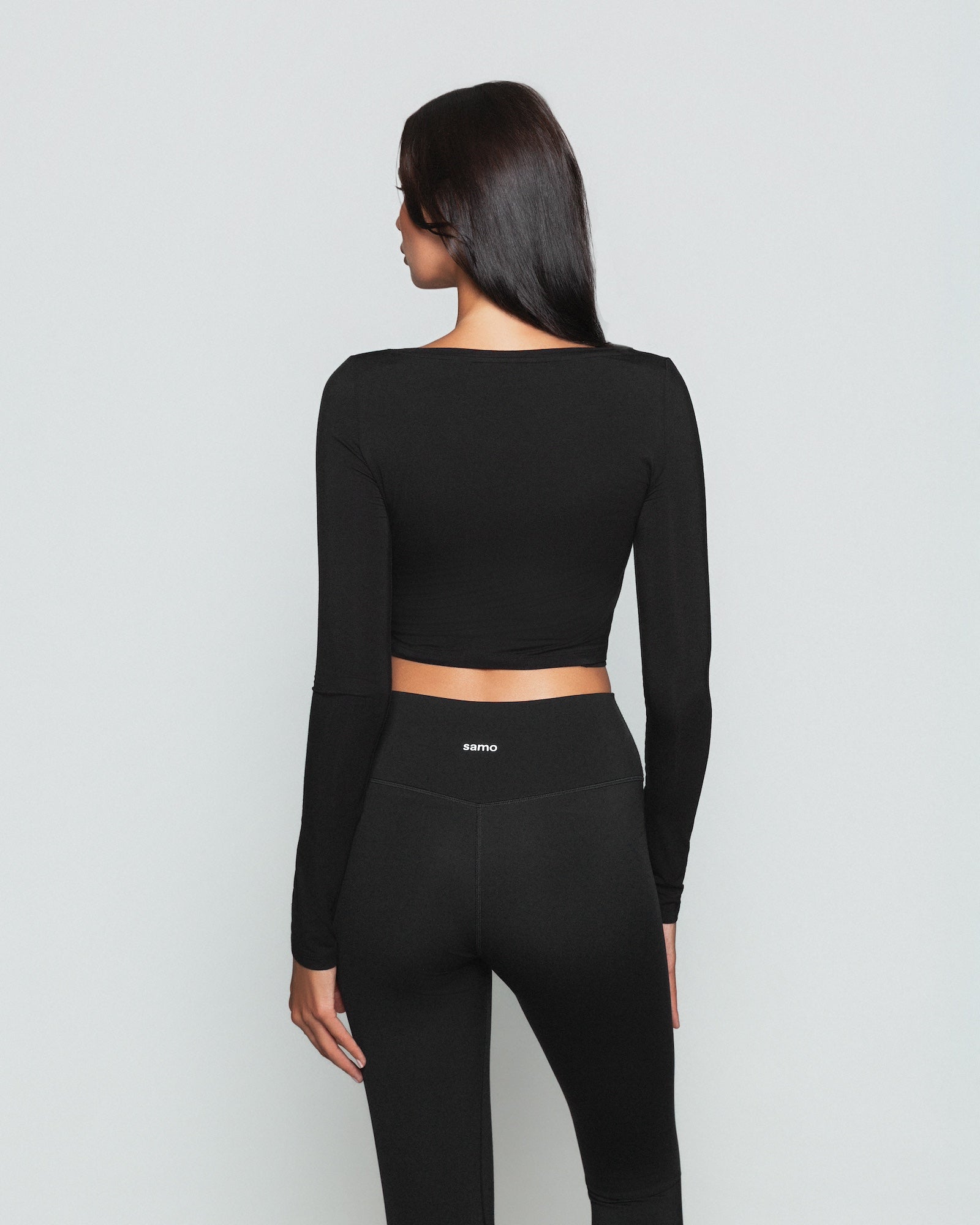 Frau trägt schwarzes Pilates Wickeloberteil von shop-samo.com