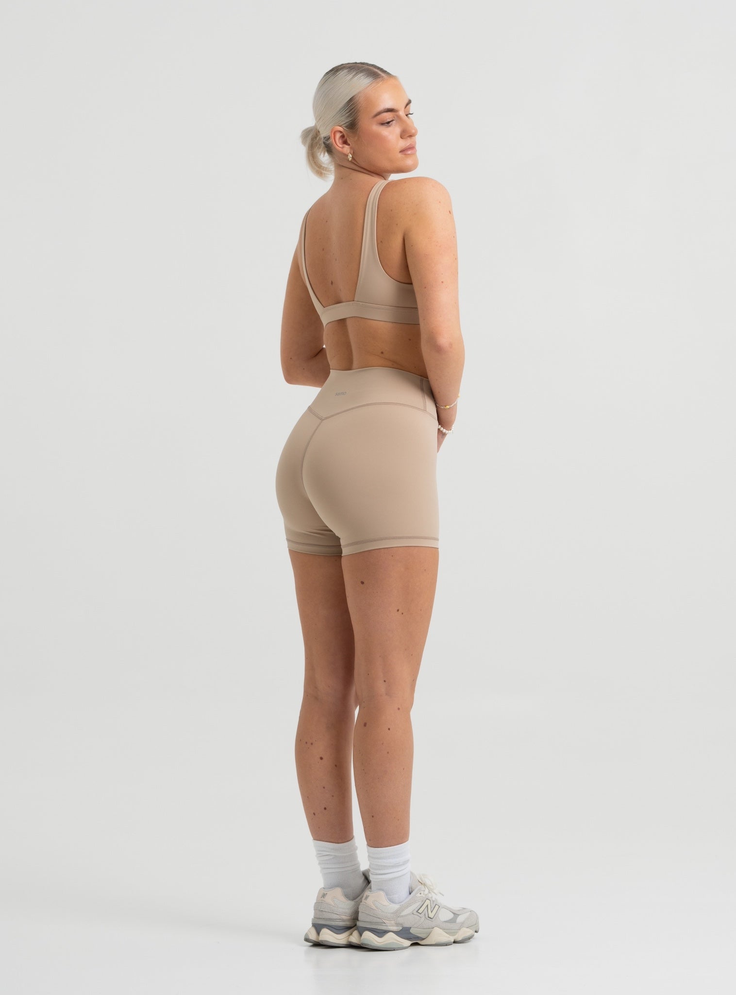 Frau trägt Seamless Pilates Shorts und Sport-BH in Sand Beige von shop-samo.com