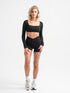 Frau trägt schwarze Cross Over Shorts und Cropped Longsleeve von shop-samo.com