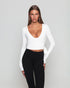 Frau trägt weisses Pilates Wickeloberteil und schwarze seamless leggings von shop-samo.com